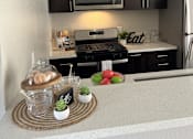 Thumbnail 34 of 45 - a kitchen with black cabinets and a counter with food on it