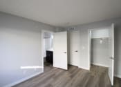 Thumbnail 13 of 20 - an empty living room with white walls and wood flooring