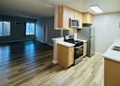 Thumbnail 5 of 36 - A kitchen with a fan and wooden floors.