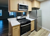 Thumbnail 4 of 36 - A kitchen with wooden cabinets and a black stove top oven.