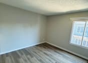Thumbnail 31 of 36 - A room with a window and wooden flooring.