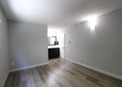 Thumbnail 6 of 31 - an empty living room with wood floors and a kitchen