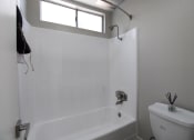 Thumbnail 11 of 31 - a bathroom with a toilet and a tub and a window