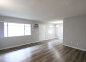 Thumbnail 7 of 31 - an empty living room with wood floors and a window