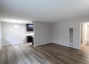 Thumbnail 4 of 31 - an empty living room with wood flooring and a kitchen