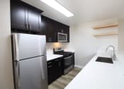 Thumbnail 20 of 45 - a kitchen with stainless steel appliances and black and white counter tops