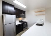 Thumbnail 2 of 45 - an apartment kitchen with stainless steel appliances and black and white counter tops