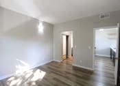 Thumbnail 8 of 45 - an empty living room with wood floors and white walls and closets