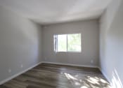 Thumbnail 25 of 45 - a empty room with wooden floors and a window
