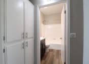 Thumbnail 10 of 45 - a view through a door into a bathroom with a toilet and sink with hallway abundant cabinet storage