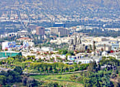 Thumbnail 30 of 30 - A cityscape with buildings and greenery in the foreground.
