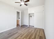 Thumbnail 29 of 40 - A room with a ceiling fan and wooden flooring.