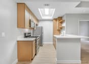 Thumbnail 16 of 30 - A kitchen with wooden cabinets and a white island.