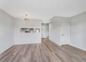 Thumbnail 22 of 35 - A room with wooden floors and a chandelier.
