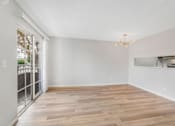 Thumbnail 25 of 35 - A room with wooden floors and a chandelier.