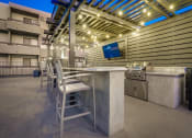Thumbnail 53 of 54 - the outdoor kitchen has a bar with chairs and a television