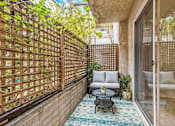 Thumbnail 7 of 30 - A patio with a table and chairs and a lattice fence.