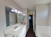 Thumbnail 9 of 18 - a bathroom with a large mirror and a sink and a tub