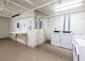 Thumbnail 28 of 37 - A laundry room with washers and dryers.