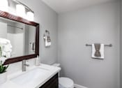 Thumbnail 4 of 37 - A white sink with a mirror above it and a towel hanging on the wall.