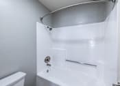 Thumbnail 32 of 37 - A white bathroom with a toilet, sink, and shower.