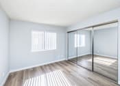 Thumbnail 21 of 37 - A room with a sliding glass door and wooden flooring.
