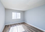 Thumbnail 20 of 37 - A room with a window and wooden flooring.