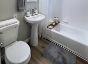 Thumbnail 4 of 49 - A white toilet sits next to a white sink in a bathroom.