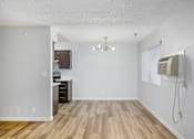Thumbnail 13 of 34 - A room with a wooden floor and a white wall with a window and a fan.