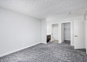 Thumbnail 7 of 34 - A sparsely furnished room with a carpeted floor and white walls.