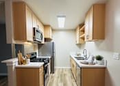Thumbnail 3 of 36 - A kitchen with wooden cabinets and a white counter.