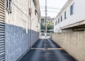 Thumbnail 20 of 31 - A narrow alley with a yellow line down the middle.