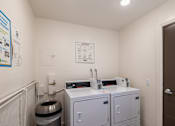 Thumbnail 22 of 31 - A small room with a toilet, a sink, and a trash can.