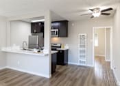 Thumbnail 21 of 31 - A kitchen with a white counter top and black cabinets.