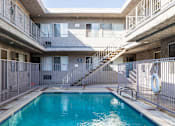 Thumbnail 24 of 31 - A pool in a courtyard surrounded by a metal fence.