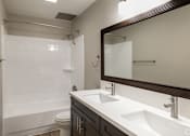Thumbnail 20 of 40 - A bathroom with a white sink and a white toilet.
