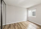 Thumbnail 19 of 40 - A room with a window and wooden flooring.