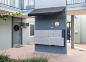 Thumbnail 22 of 40 - A mailbox is located on the sidewalk outside a building.