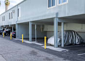 Thumbnail 30 of 40 - A parking garage with a car parked under a covered area.