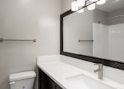 Thumbnail 32 of 40 - A white sink with a silver faucet and a mirror above it.