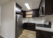Thumbnail 37 of 40 - A kitchen with a black fridge and black cabinets.