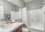 Thumbnail 3 of 35 - A white bathroom with a towel on the counter.