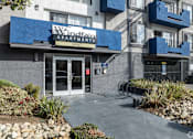 Thumbnail 17 of 31 - The image shows the front of the Windfaith Apartments building with a blue awning and glass doors.
