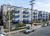 Thumbnail 23 of 31 - A row of modern apartment buildings with blue balconies.