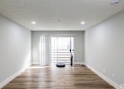 Thumbnail 12 of 31 - A room with wooden floors and a large window with blinds.