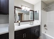 Thumbnail 4 of 31 - A bathroom with a white sink and a mirror above it.