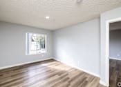 Thumbnail 7 of 31 - A room with a window and wooden flooring.