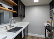 Thumbnail 29 of 31 - A kitchen with a sink and a dishwasher.