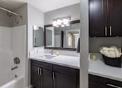 Thumbnail 27 of 31 - A bathroom with a white sink and a mirror above it.