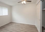 Thumbnail 6 of 9 - A room with a ceiling fan and a door.